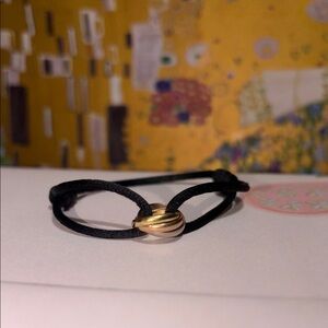 Cartier Gold Knot Bracelet with Black Cord
18K white, rose, yellow gold.